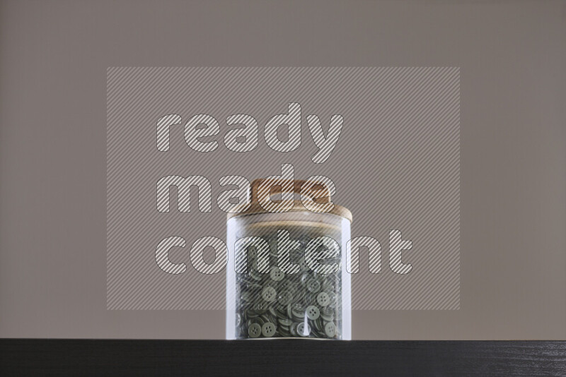 Buttons in a glass jar on black background