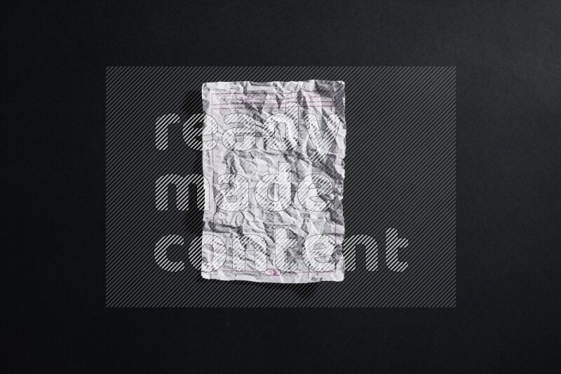 Crumpled notebook sheet on black background