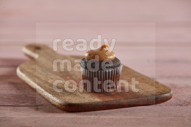 Chocolate mini cupcake topped with peanut butter on a wooden board
