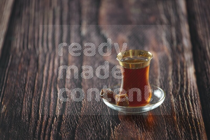 A tea glass cup with dates and coffee on wooden background