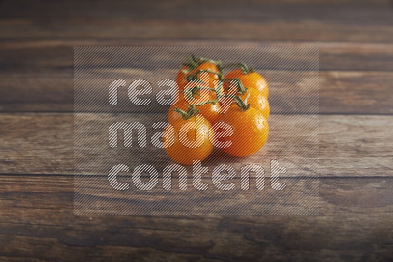 Orange cherry tomato vein on a textured wooden background 45 degree