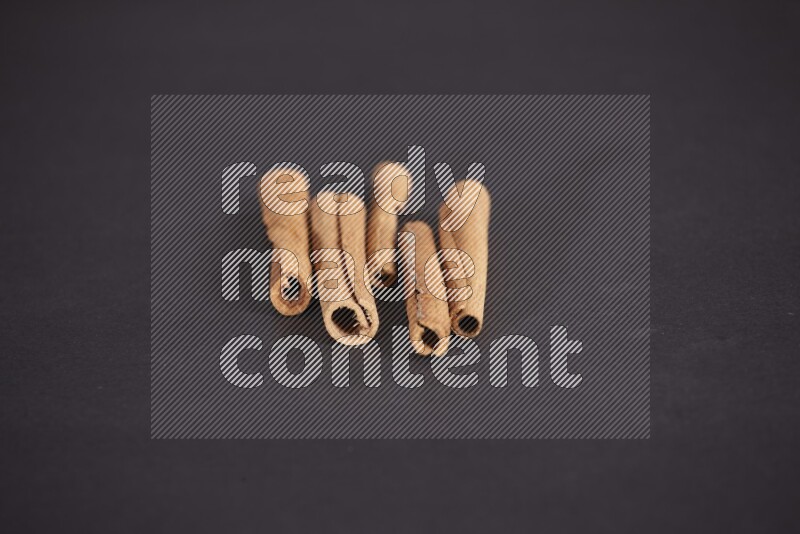 Cinnamon sticks stacked on black flooring