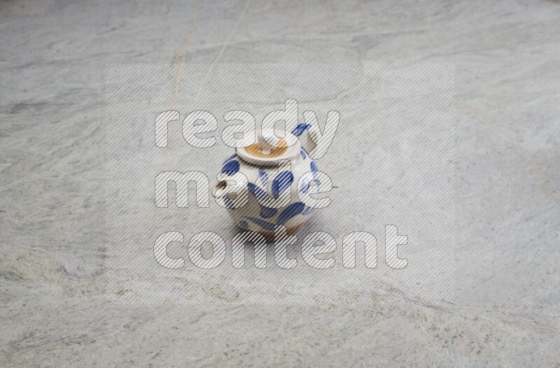 A pottery teapot on grey marble background