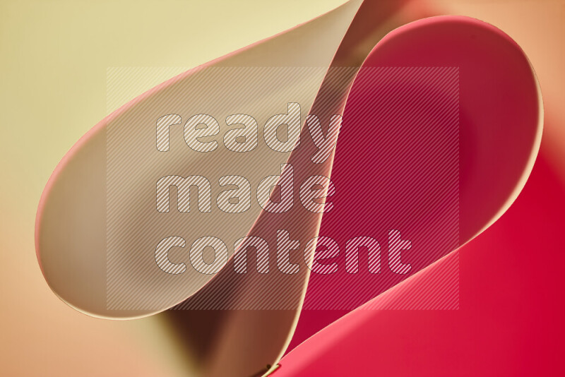An abstract art of paper folded into smooth curves in yellow and red gradients