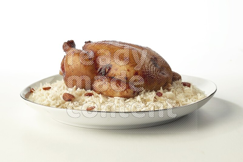 white  basmati Rice with  whole roasted chicken  on a white plate with a silver rim direct  on white background