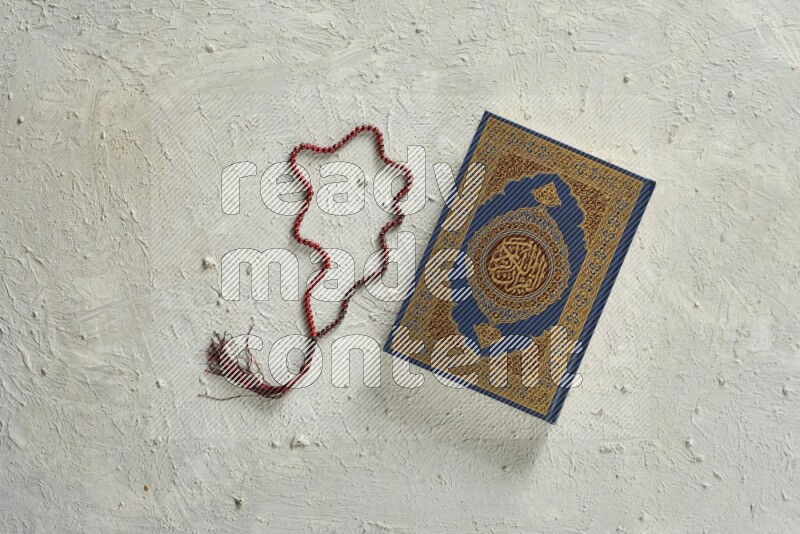 Quran with a prayer beads on white background
