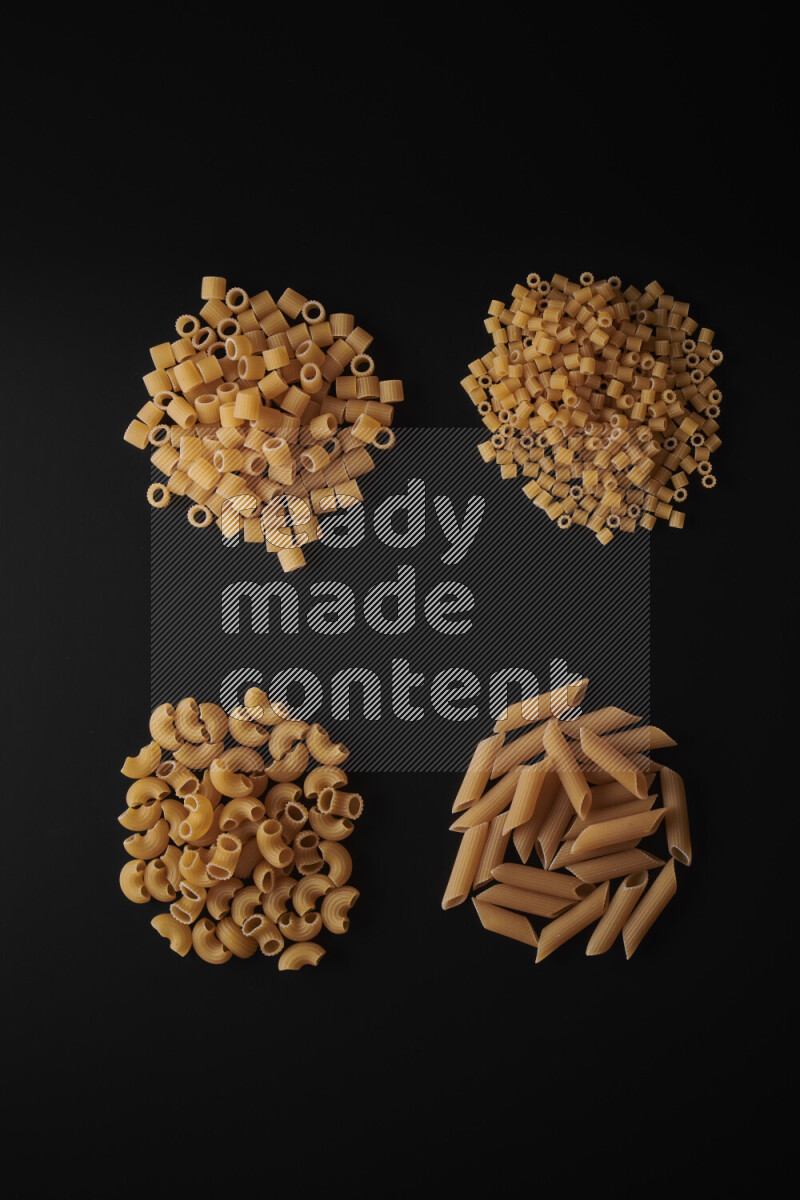 Different pasta types in bunches on black background