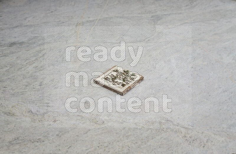 Top view shot of a pottery coaster\ tile on beige marble flooring