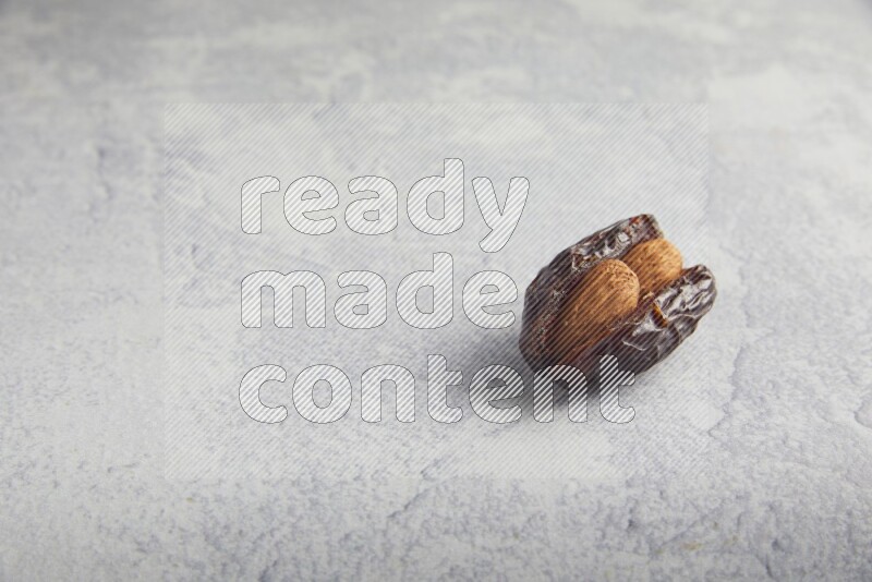 almond stuffed madjoul date on a light grey background
