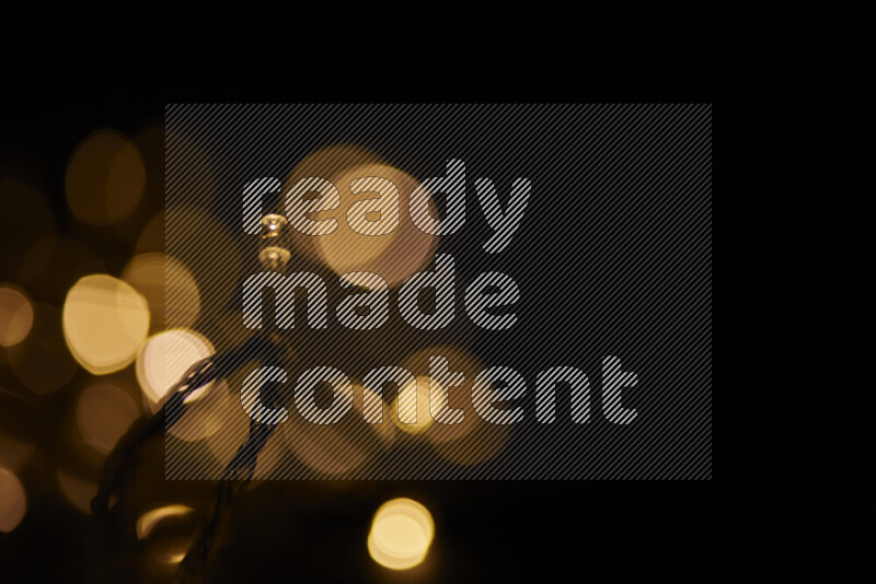 Light bulbs glowing against backdrop of golden bokeh