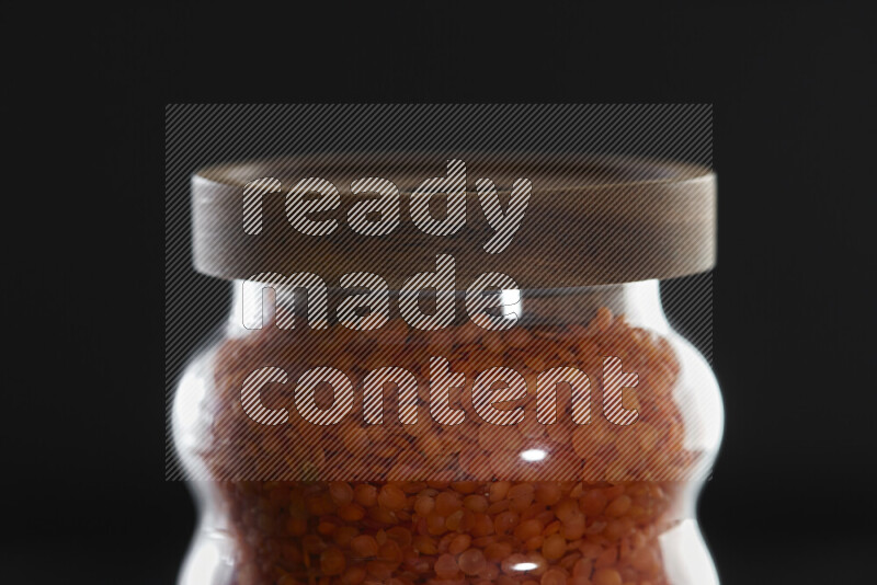 Lentils in a glass jar on black background