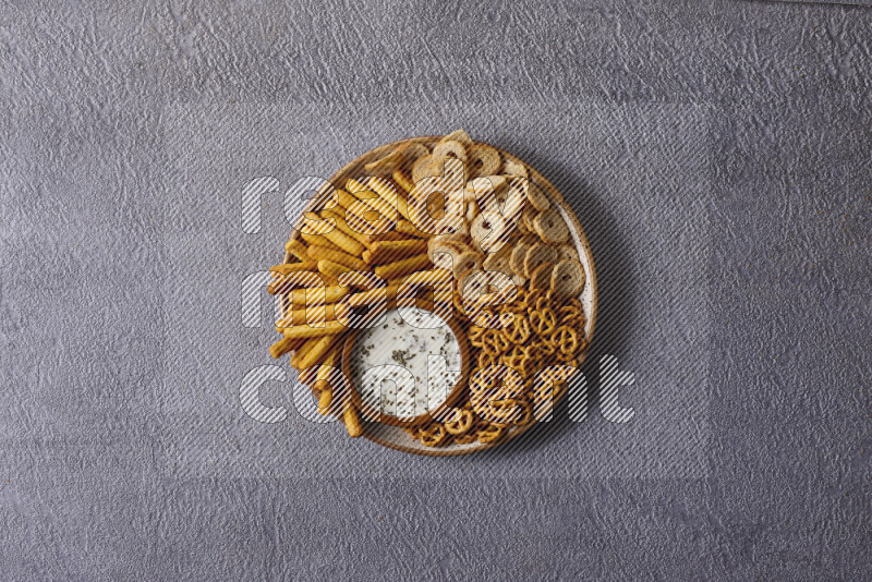 Assorted snacks in pottery bowls on grey background