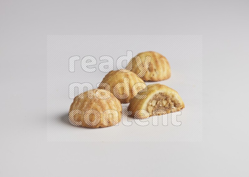 Four Pieces of Maamoul filled with walnut paste  one of them is cut direct on white background