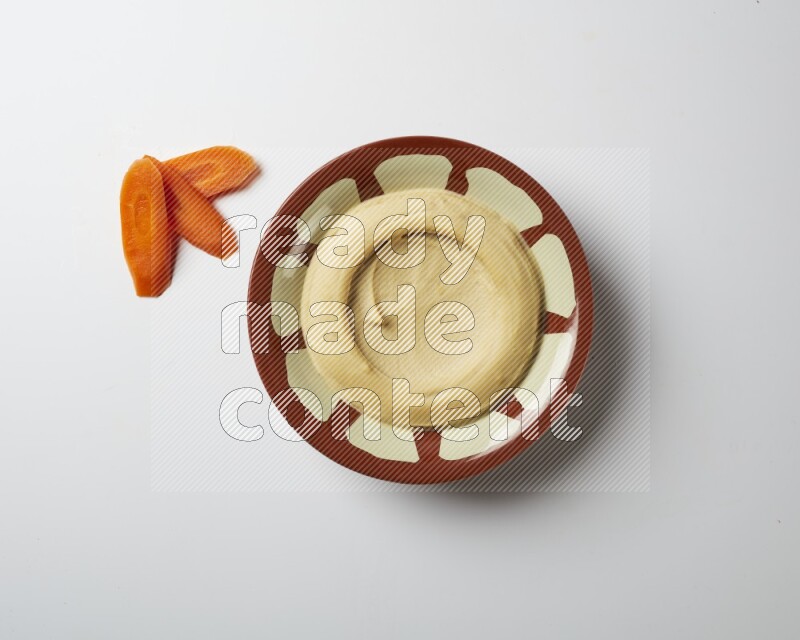 Plain hummus in a traditional plate on a white background