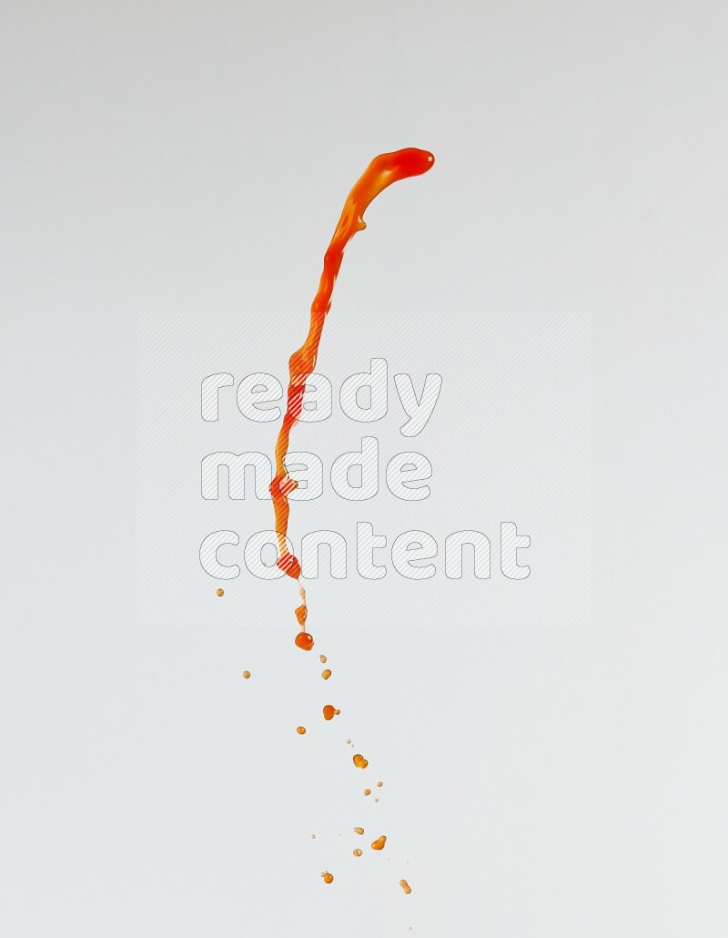 Orange liquid splash and drops on white background