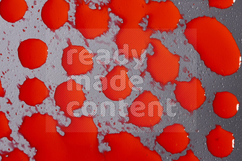 Close-ups of abstract red paint droplets on grey background