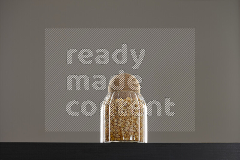 Pop corn in a glass jar on black background