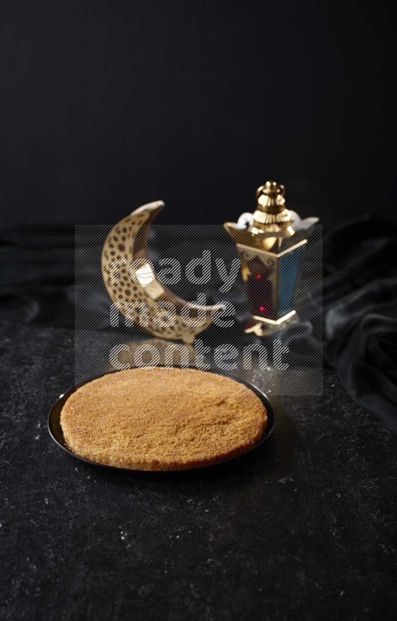 كنافة مع فوانيس علي خلفية سوداء خشبية