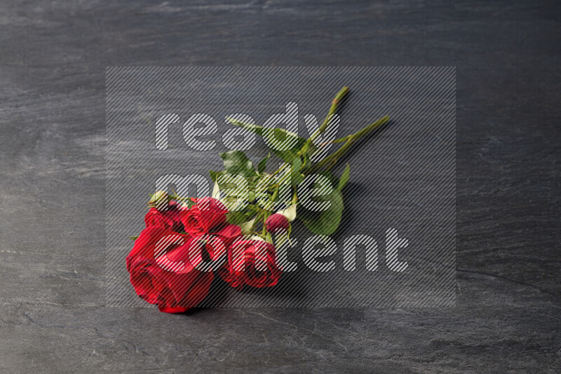Red roses in different sizes on black marble background