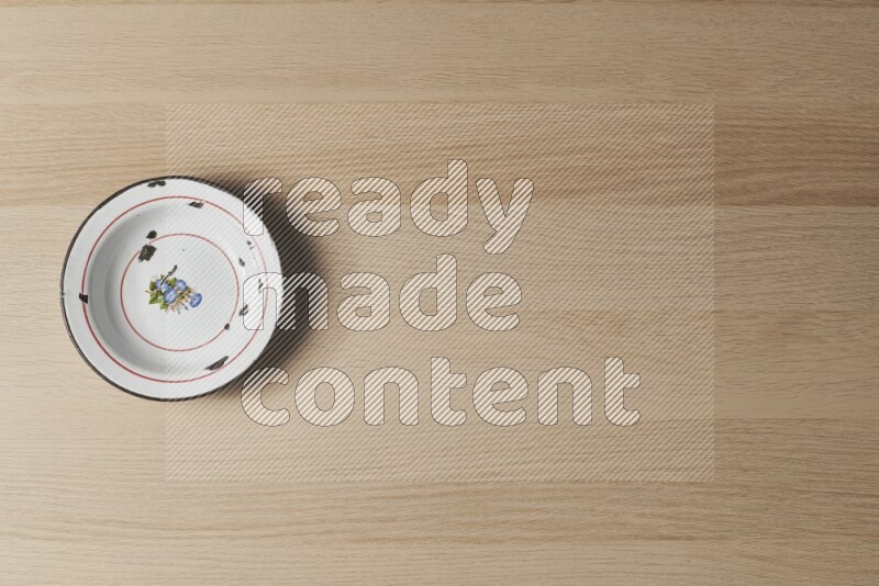 صحن معدني عتيق على خلفية خشبية فاتحة