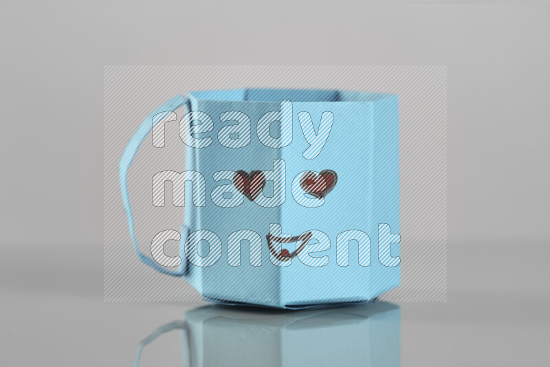 Origami cup on grey background