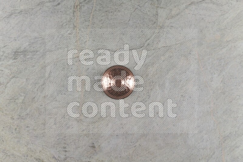 A small copper pot on grey marble background
