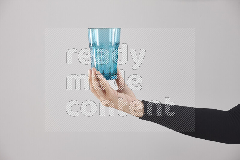 A woman in black abaya holding different glassware in different positions