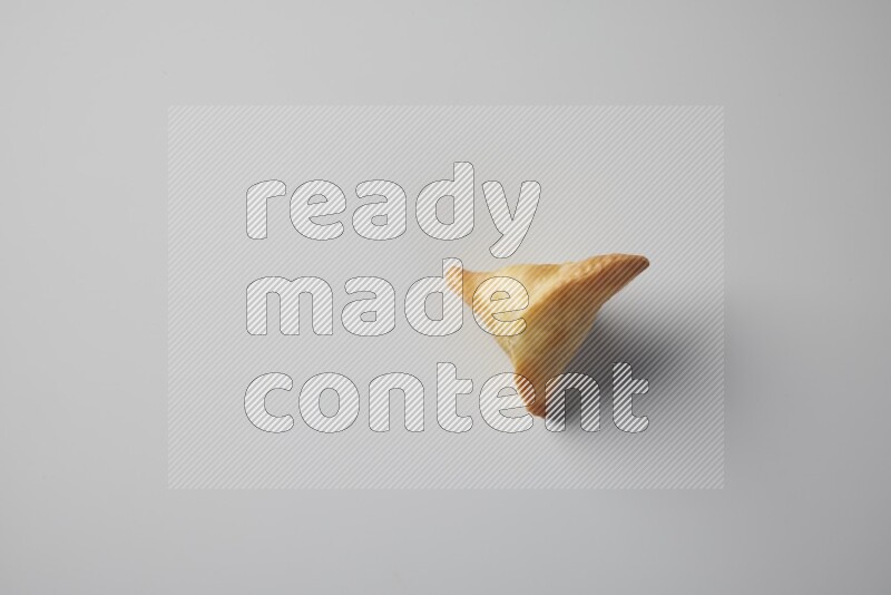 One fried sambosa from a top angle on a white background