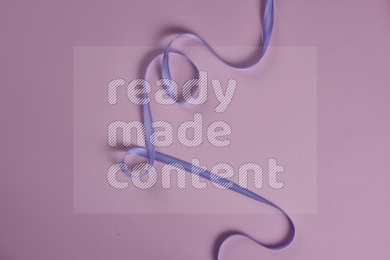 A purple and pink collection of sewing and tailoring tools arranged on a pink background