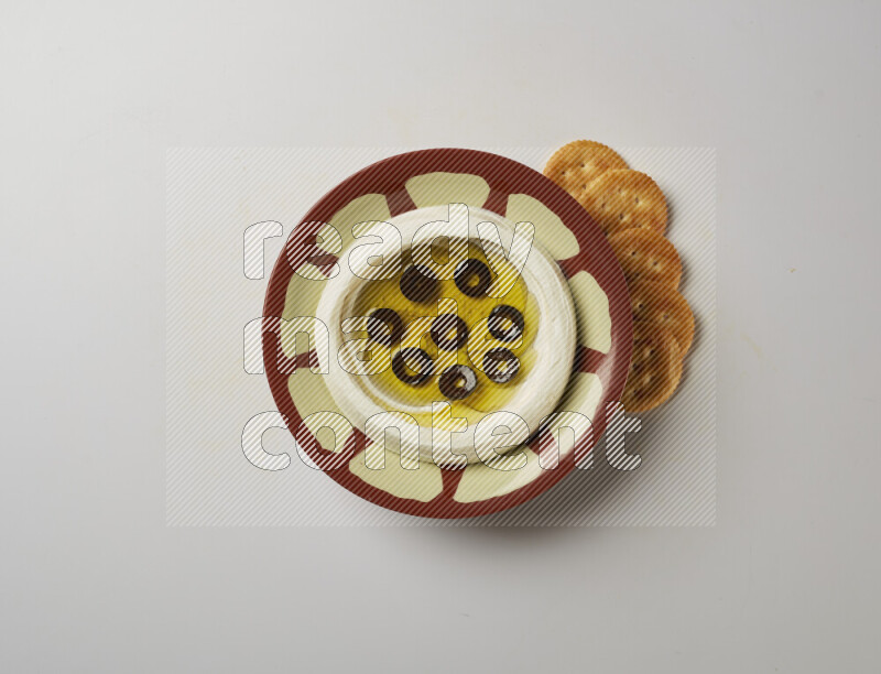 Lebnah garnished with sliced olives in a traditional plate on a white background