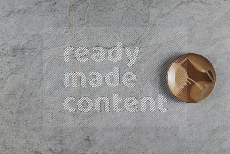 A multicolored pottery plate on grey marble background