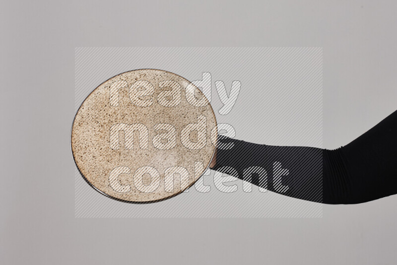 A woman in black abaya holding different pottery essentials in different positions