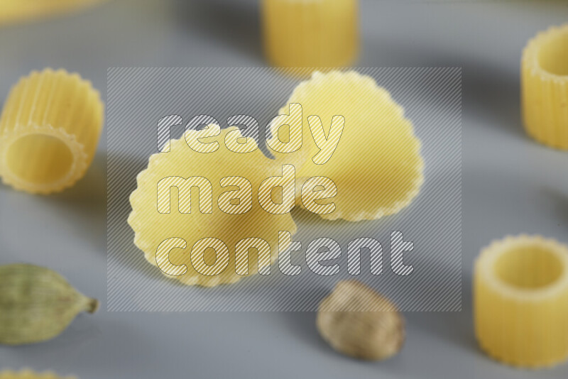 معكرونة مع مكونات متنوعة من الطماطم والثوم والبصل والفلفل الأحمر والفلفل الأسود والفلفل الأبيض وأوراق الغار وإكليل الجبل والهيل و مشروم على خلفية زرقاء فاتحة