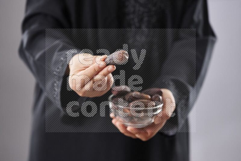 Woman in abaya holding dates in different positions