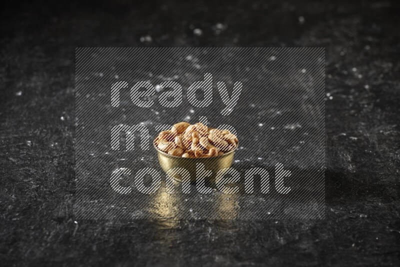 Nuts in a metal bowl in a dark setup