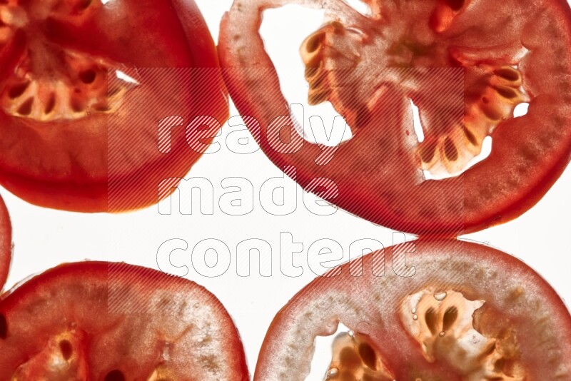 Tomatoes slices on illuminated white background