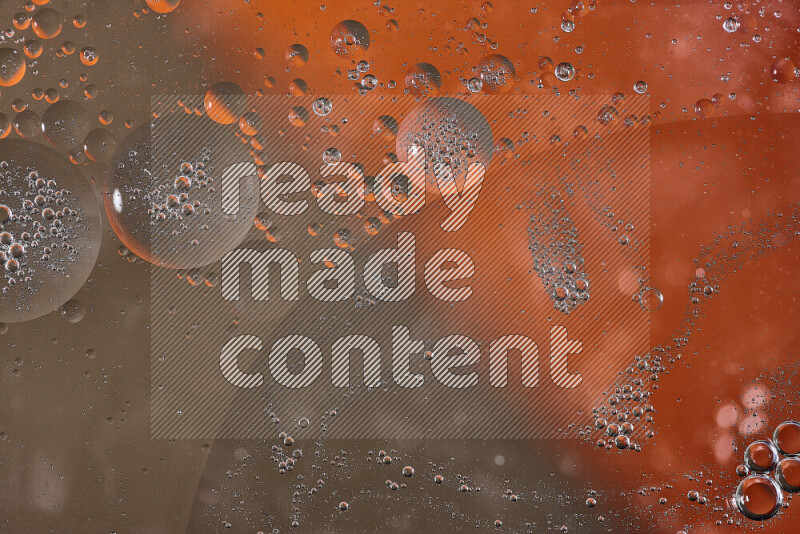 Close-ups of abstract oil bubbles on water surface in shades of orange and brown