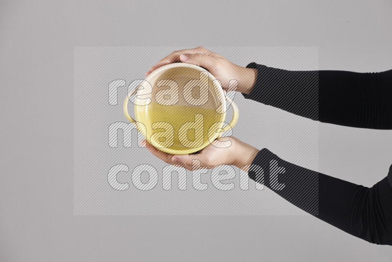 A woman in black abaya holding different pottery essentials in different positions