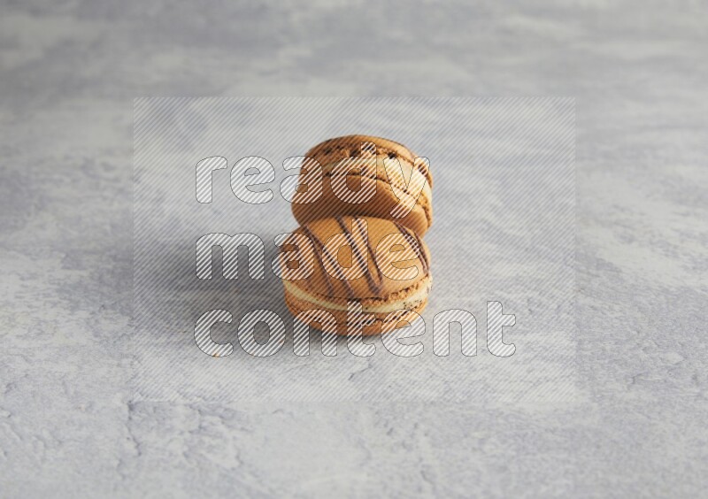 45º Shot of two light brown  Almond Cream macarons  on white  marble background