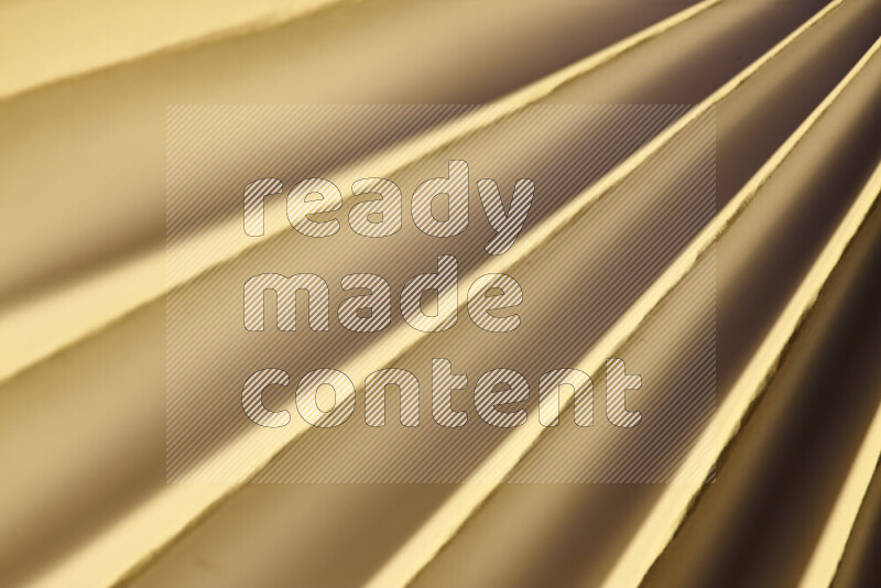 An image presenting an abstract paper pattern of lines in gold tones