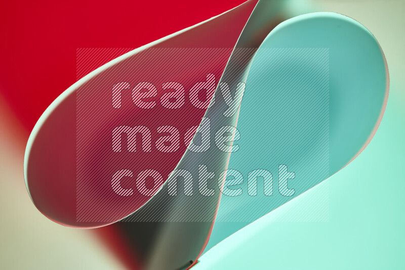 An abstract art of paper folded into smooth curves in green and red gradients