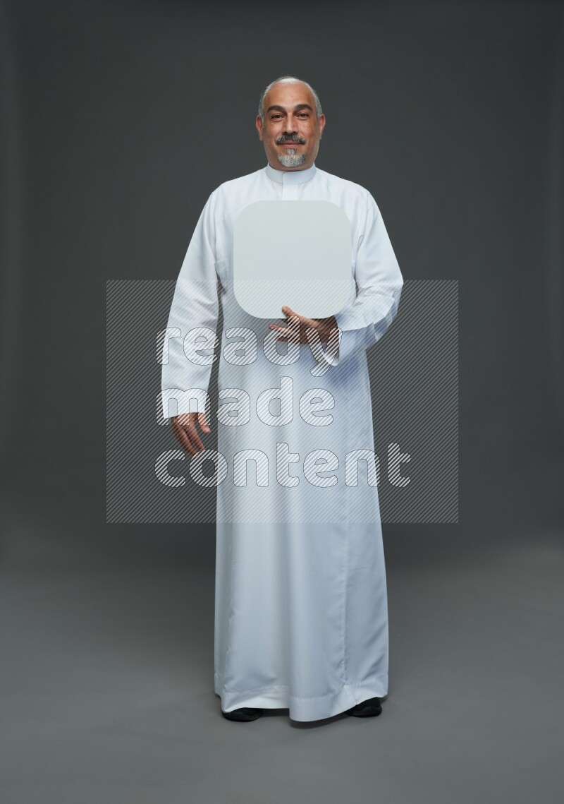 Saudi man without shomag Standing holding social media sing on gray background