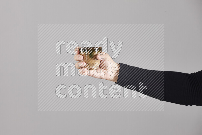 A woman in black abaya holding different pottery essentials in different positions