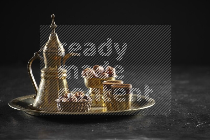 Nuts with dates and a drink on a metal tray in a dark setup