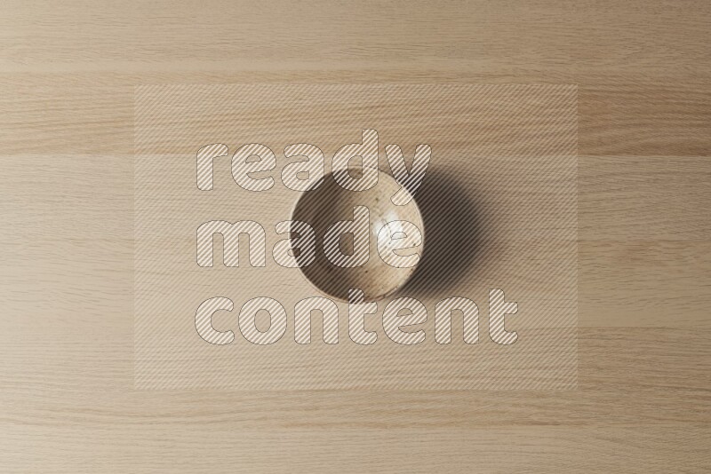 وعاء فخاري متعدد الألوان على خلفية خشبية فاتحة