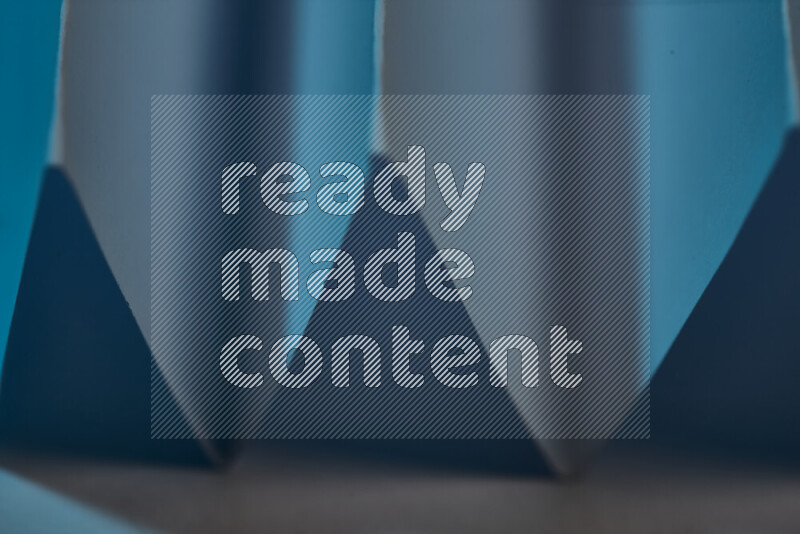 صورة مجردة مقربة تظهر طيات ورقية هندسية حادة بتدرجات اللون الأزرق