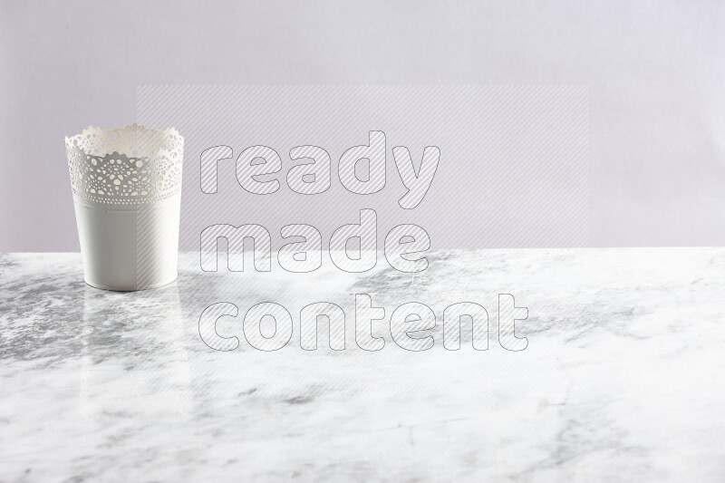 An empty white plant pot on grey marble background