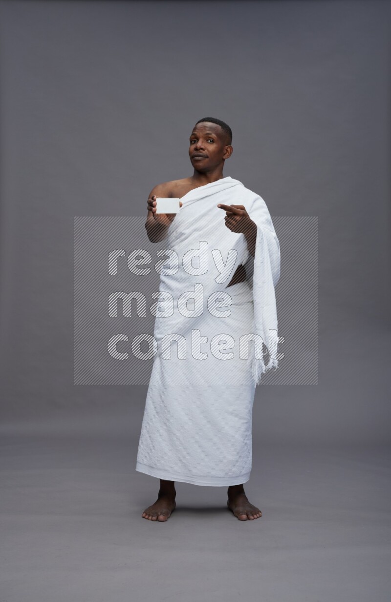 A man wearing Ehram Standing holding ATM card on gray background