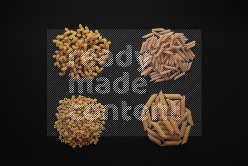 Different pasta types in bunches on black background