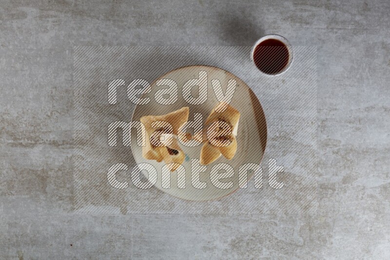 wonton cups with soy sauce ramkin on multi colored pottery on grey textured counter top